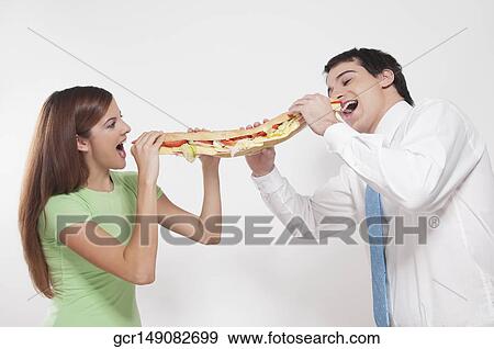 Man and a woman sharing a submarine sandwich View Large Photo Image Stock Photo - Man and a woman sharing a submarine sandwich. Fotosearch