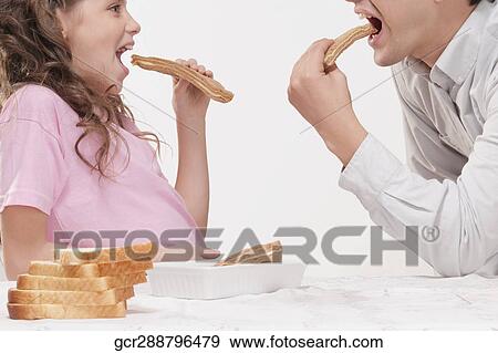Man and his daughter eating breads View Large Photo Image Stock Photo - Man and his daughter eating breads. Fotosearch