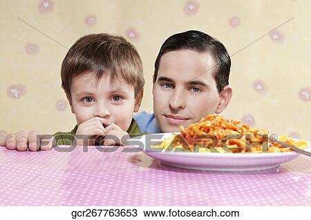 Man and his son with a plate of fettuccine pasta View Large Photo Image Stock Image - Man and his son with a plate of fettuccine pasta. Fotosearch