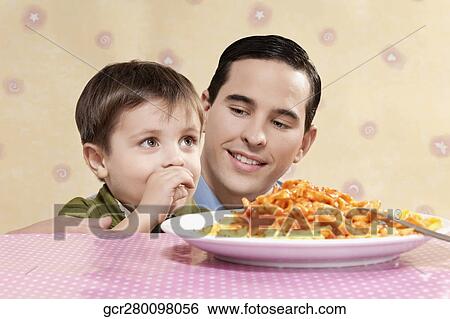 Man and his son with a plate of fettuccine pasta View Large Photo Image Stock Photograph - Man and his son with a plate of fettuccine pasta. Fotosearch