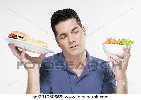 Man choosing between a hamburger plate and a salad bowl View Large Photo Image Stock Photography - Man choosing between a hamburger plate and a salad bowl. Fotosearch