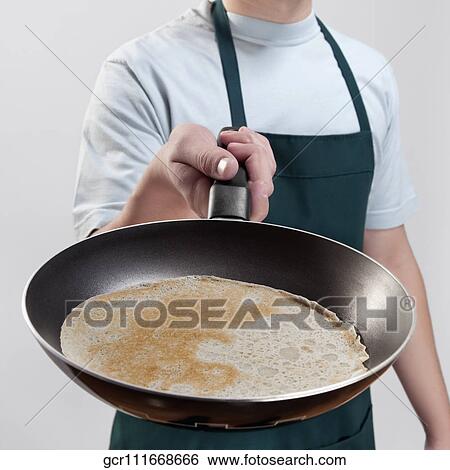 Stock Photograph - Man cooking omelet. Fotosearch