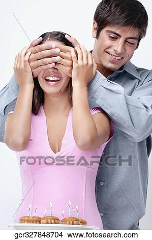 Picture - Man covering a woman's eyes from behind. Fotosearch