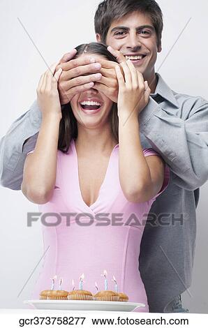 Man covering a woman's eyes from behind View Large Photo Image Stock Photo - Man covering a woman's eyes from behind. Fotosearch