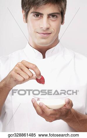 Man dipping a strawberry in cream and smiling View Large Photo Image Stock Photography - Man dipping a strawberry in cream and smiling. Fotosearch