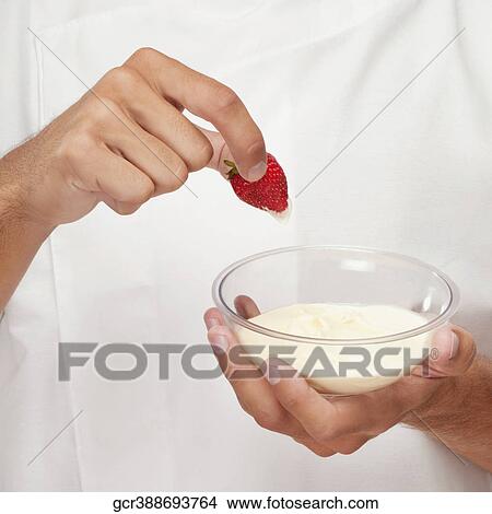Man dipping a strawberry in cream View Large Photo Image Picture - Man dipping a strawberry in cream. Fotosearch