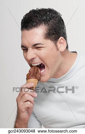 Man eating a chocolate ice cream and looking angry View Large Photo Image Stock Photo - Man eating a chocolate ice cream and looking angry. Fotosearch