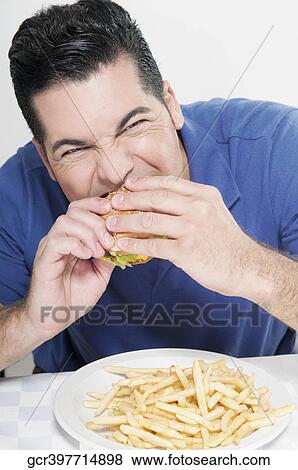 Man eating a hamburger View Large Photo Image Stock Photo - Man eating a hamburger. Fotosearch