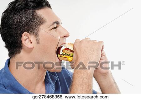 Man eating a hamburger View Large Photo Image Stock Photograph - Man eating a hamburger. Fotosearch