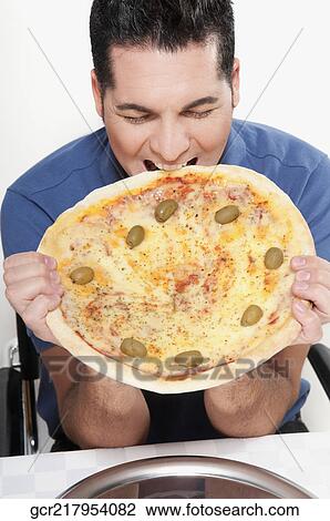 Man eating a pizza pie View Large Photo Image Stock Image - Man eating a pizza pie. Fotosearch