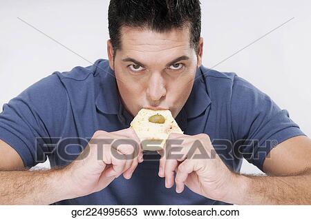 Stock Image - Man eating a slice of pizza. Fotosearch
