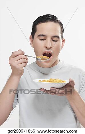 Man eating corn flakes View Large Photo Image Stock Photograph - Man eating corn flakes. Fotosearch