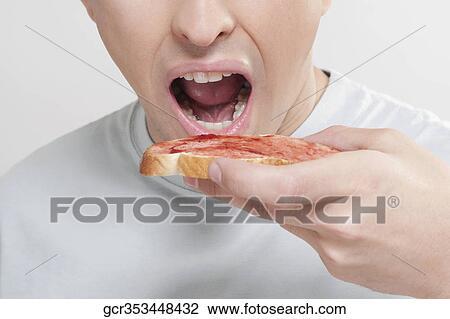 Man eating jam on toast View Large Photo Image Stock Image - Man eating jam on toast. Fotosearch