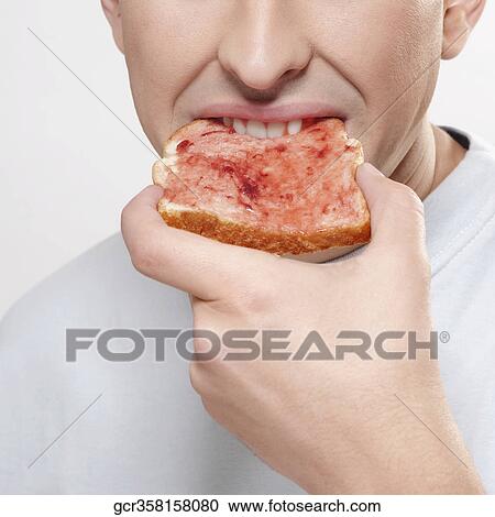 Man eating jam on toast View Large Photo Image Stock Image - Man eating jam on toast. Fotosearch