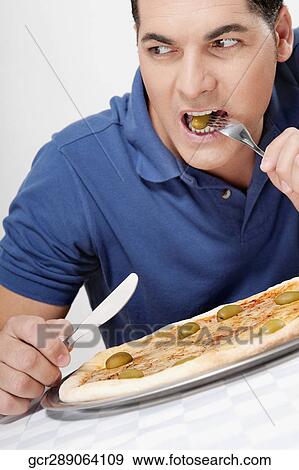 Man eating pizza with a fork and knife View Large Photo Image Stock Photo - Man eating pizza with a fork and knife. Fotosearch