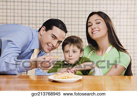 Man feeding French fries to his son View Large Photo Image Stock Photography - Man feeding French fries to his son. Fotosearch