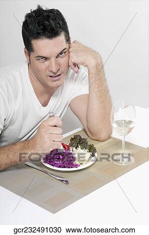 Man frowning over a salad View Large Photo Image Stock Image - Man frowning over a salad. Fotosearch