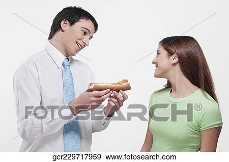 Man giving a hot dog to his wife View Large Photo Image Stock Photo - Man giving a hot dog to his wife. Fotosearch