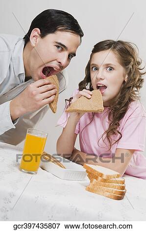 Man having breakfast with his daughter View Large Photo Image Stock Photo - Man having breakfast with his daughter. Fotosearch