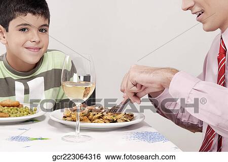 Man having lunch with his son View Large Photo Image Stock Photograph - Man having lunch with his son. Fotosearch