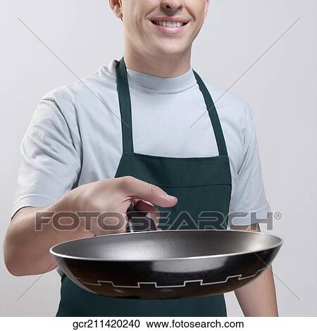 Man holding a frying pan View Large Photo Image Stock Image - Man holding a frying pan. Fotosearch