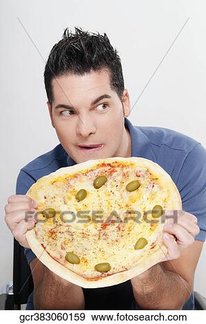Man holding a pizza View Large Photo Image Stock Photo - Man holding a pizza. Fotosearch