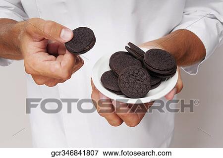 Man holding a plate of chocolate cookies View Large Photo Image Stock Photo - Man holding a plate of chocolate cookies. Fotosearch