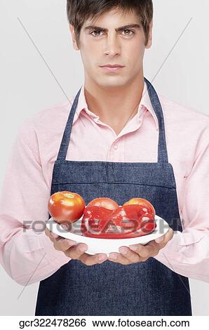 Man holding a plate of red bell peppers and tomatoes View Large Photo Image Stock Photograph - Man holding a plate of red bell peppers and tomatoes. Fotosearch
