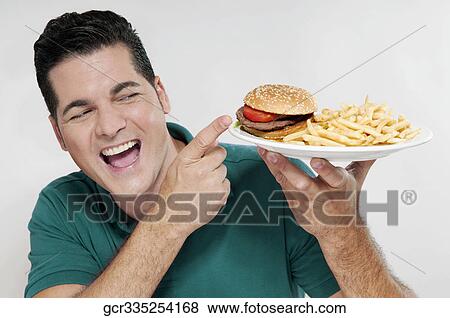 Man pointing to a plate of hamburger and fries View Large Photo Image Stock Photo - Man pointing to a plate of hamburger and fries . Fotosearch