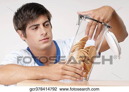 Man reaching into a jar of cookies View Large Photo Image Stock Image - Man reaching into a jar of cookies. Fotosearch