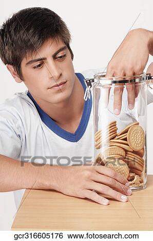 Man reaching into a jar of cookies View Large Photo Image Stock Photograph - Man reaching into a jar of cookies. Fotosearch
