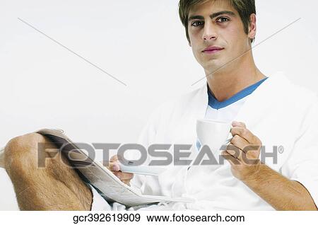 Man reading a newspaper with a cup of coffee View Large Photo Image Stock Photo - Man reading a newspaper with a cup of coffee. Fotosearch