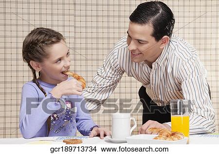 Man with his daughter at a breakfast table View Large Photo Image Picture - Man with his daughter at a breakfast table. Fotosearch