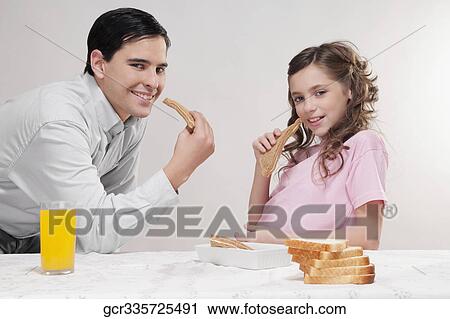 Man with his daughter at a breakfast table View Large Photo Image Stock Image - Man with his daughter at a breakfast table. Fotosearch