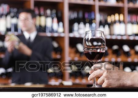 Man's hand holding a wine glass in a bar View Large Photo Image Stock Image - Man's hand holding a wine glass in a bar. Fotosearch