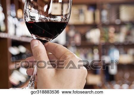 Man's hand holding a wine glass in a bar View Large Photo Image Stock Photograph - Man's hand holding a wine glass in a bar. Fotosearch