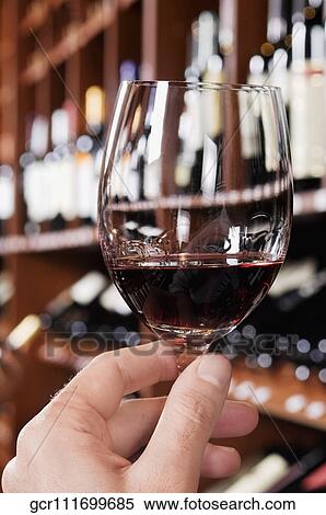 Man's hand holding a wine glass in a bar View Large Photo Image Stock Photography - Man's hand holding a wine glass in a bar. Fotosearch