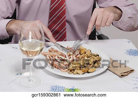 Mid section view of a businessman having lunch View Large Photo Image Stock Image - Mid section view of a businessman having lunch. Fotosearch