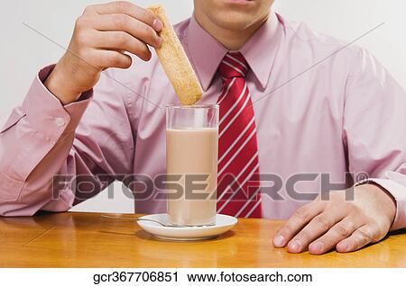 Mid section view of a businessman dipping a wafer in milk View Large Photo Image Stock Image - Mid section view of a businessman dipping a wafer in milk. Fotosearch