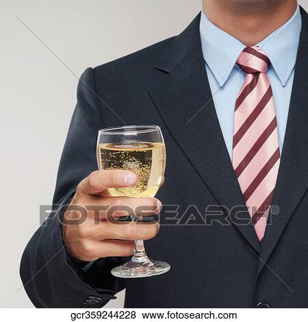 Mid section view of a businessman holding a glass of white wine View Large Photo Image Stock Photo - Mid section view of a businessman holding a glass of white wine. Fotosearch