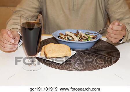 Mid section view of a man eating salad View Large Photo Image Stock Photo - Mid section view of a man eating salad. Fotosearch