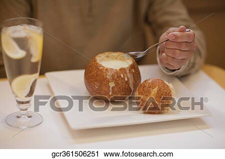 Mid section view of a man eating soup from a bread bowl View Large Photo Image Stock Image - Mid section view of a man eating soup from a bread bowl. Fotosearch
