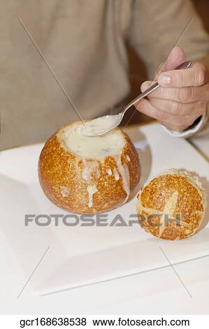 Mid section view of a man eating soup from a bread bowl View Large Photo Image Stock Photo - Mid section view of a man eating soup from a bread bowl. Fotosearch