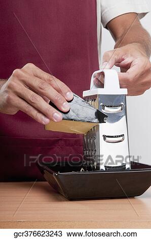 Mid section view of a man grating cheese View Large Photo Image Stock Image - Mid section view of a man grating cheese. Fotosearch