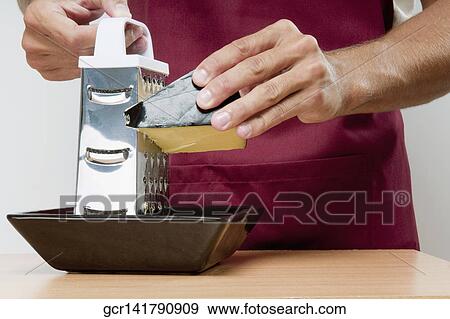 Mid section view of a man grating cheese View Large Photo Image Stock Photo - Mid section view of a man grating cheese. Fotosearch