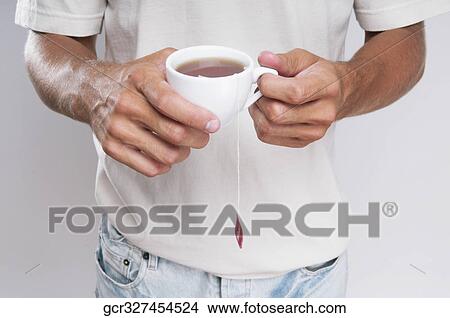 Mid section view of a man holding a cup of coffee View Large Photo Image Picture - Mid section view of a man holding a cup of coffee. Fotosearch
