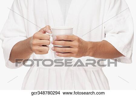 Mid section view of a man holding a cup of coffee View Large Photo Image Picture - Mid section view of a man holding a cup of coffee. Fotosearch
