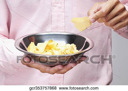 Mid section view of a man holding a bowl of chips View Large Photo Image Stock Photo - Mid section view of a man holding a bowl of chips. Fotosearch