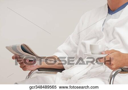 Mid section view of a man holding a newspaper View Large Photo Image Stock Photography - Mid section view of a man holding a newspaper. Fotosearch