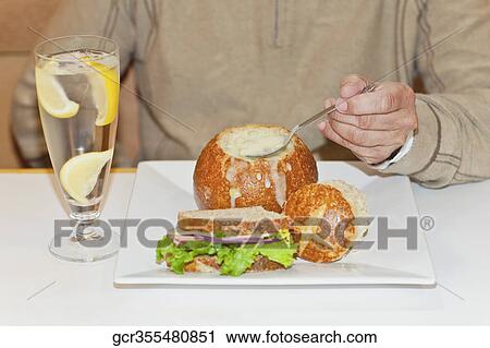 Stock Image - Mid section view of a person eating granadilla. Fotosearch
